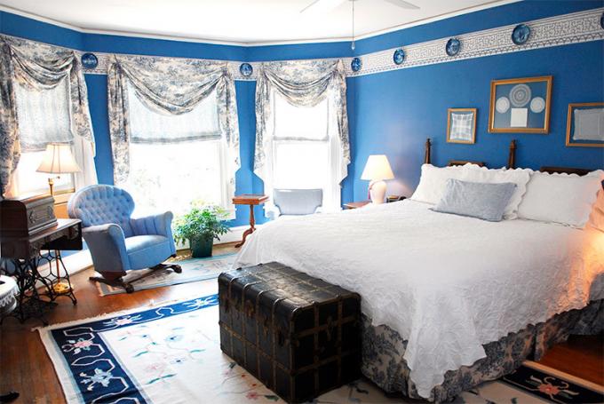 Kuva makuuhuoneesta, jossa on siniset seinät tilan vähentämiseksi