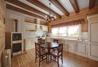 Provence-tyylinen keittiö, jossa on puulattiat ja kattopalkit.